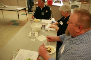 Judges Shawn O'Donnell, Tana Baumler, and Kay Nelson (left to right respectively) sample a dish. The adjudicators had significant difficulty when determining winners due to the excellence of all the dishes.