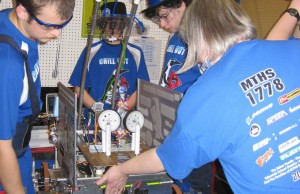 Members of the 2011 robotics team work to assemble their robot at the kickoff event.