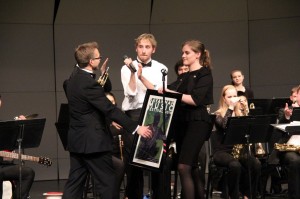 Jazz 1 members Alicia Smith (right) and Henry Sparks (left) present band director Darin Faul with a framed commemorative poster from the Swing Central jazz festival in Savannah, Ga., signed by all of the Jazz 1 members.